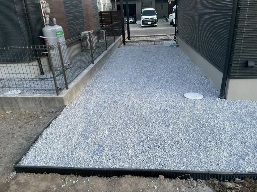 敷地内の砂利敷き施工後の様子。6号砕石を敷き均し、見切り材でラインを整えた八潮市O様邸の外構