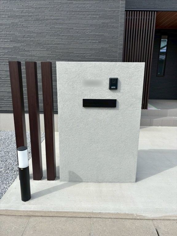 ジョリパッド仕上げの門袖と表札ONDAの施工後。ブラックポストとインターホンを埋め込んだ八潮市O様邸の門まわり