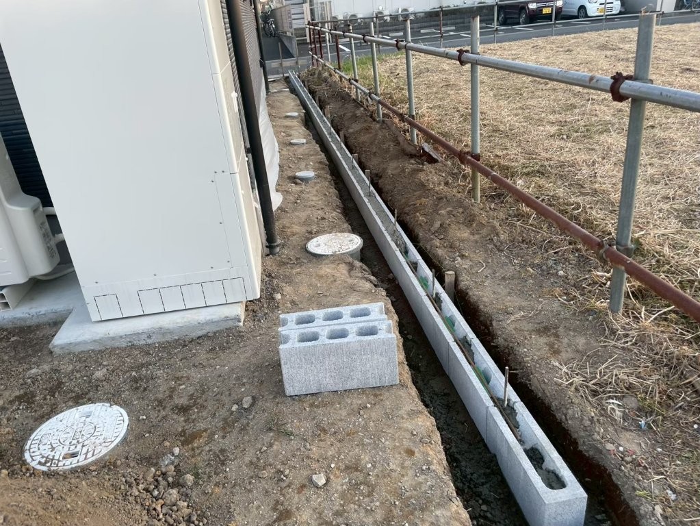 建物脇の境界部でブロック積みを進める施工中の状況。フェンス設置に向けて外周ラインを整えている八潮市の新築外構工事