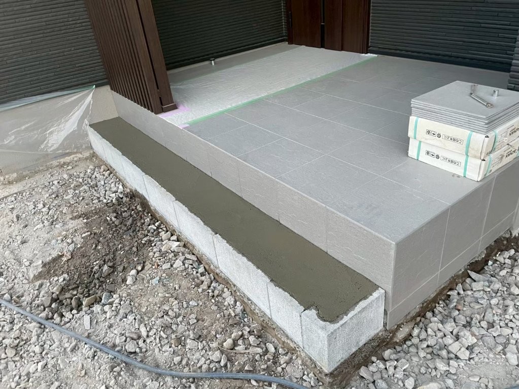 タイル立上りや段差部の左官仕上げ施工中。見切りラインを整えて納まりを良くする八潮市O様邸の外構工事